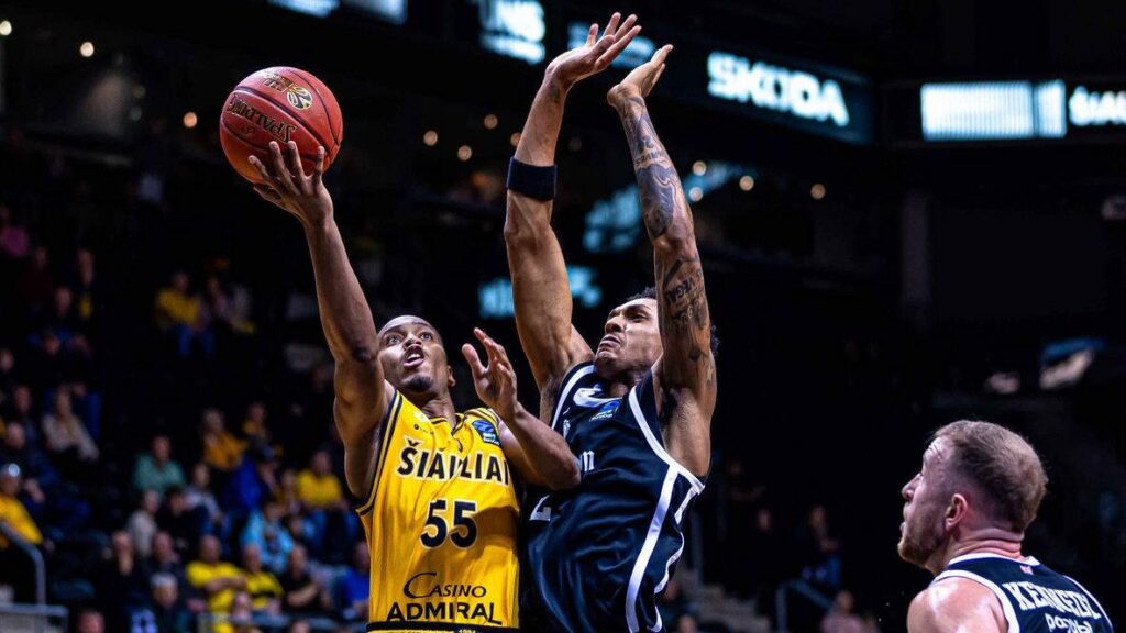 Šiauliai player attacks the basket against two London Lions defenders